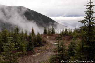 A scenic view of the road back down to the lake. The fraser valley off in the distance obscured by cloud.
