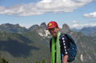 Liam on the Summit of Mt Strachan with the Lions as a back-drop